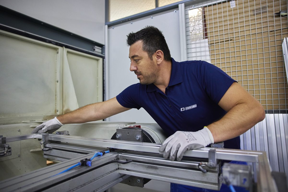 Mitarbeiter bearbeitet Aluminiumprofile an einer Maschine